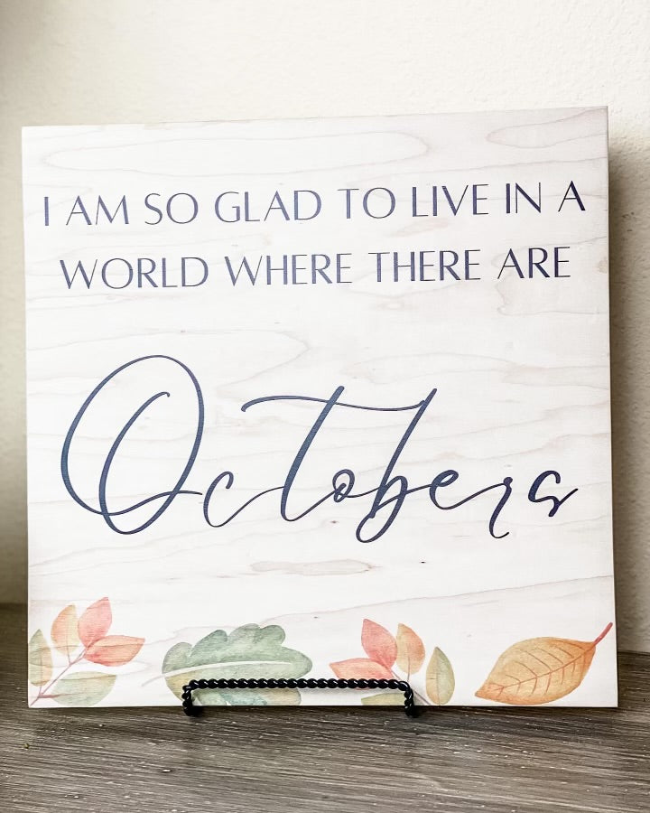 Wooden handcrafted October sign with pumpkins.